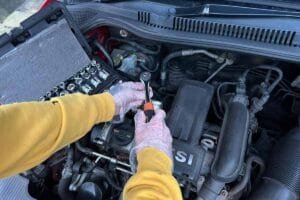 essential car maintenance for beginners - hands fixing car engine