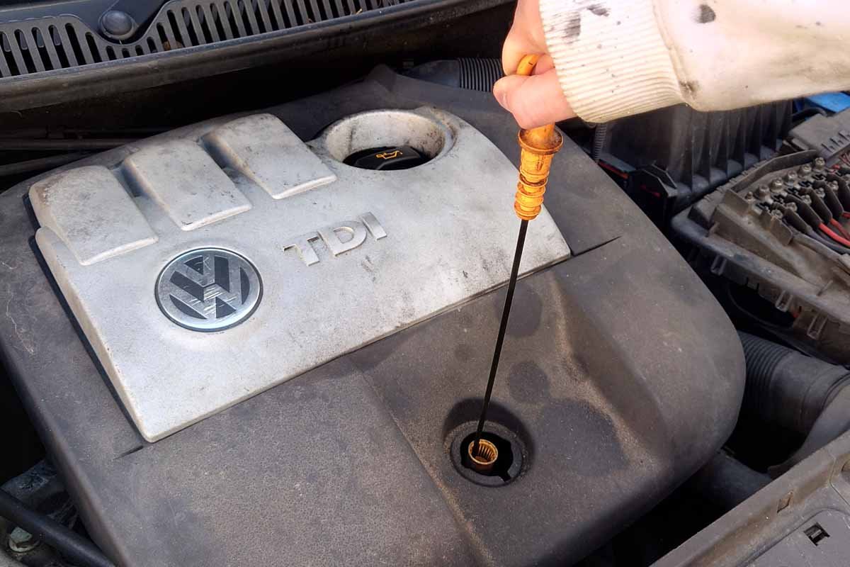 how to check your car oil - pulling dipstick